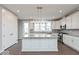 Bright kitchen featuring white cabinets, stainless steel appliances, a large island, and wood-look flooring at 7340 W County Road 600 Rd, McCordsville, IN 46055