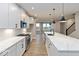 Modern kitchen featuring stainless steel appliances, white cabinets, an island with a sink, and sleek hardwood flooring at 7344 W County Road 600, McCordsville, IN 46055
