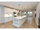 Spacious kitchen with white cabinets, stainless steel appliances, a large island, and wood flooring at 7344 W County Road 600, McCordsville, IN 46055
