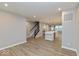 Open concept living space with wood flooring and modern staircase with views of the kitchen at 7344 W County Road 600, McCordsville, IN 46055