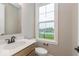 Well lit bathroom with a wooden cabinet and a window above the toilet at 7348 W County Road 600 Rd # 12-604, McCordsville, IN 46055