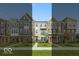 View of new townhomes showcasing brick and siding exteriors, complemented by well-maintained lawns and inviting walkways at 7348 W County Road 600 Rd # 12-604, McCordsville, IN 46055