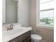 Bathroom with white countertop, dark cabinets, and a window at 7352 W County Road 600, McCordsville, IN 46055