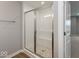 Walk-in shower featuring a glass door and seat, stone floors, and modern fixtures at 7352 W County Road 600, McCordsville, IN 46055