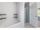 Bright bathroom featuring a soaking tub, shower, tile floors, and built in shelves for storage and organization at 800 Gondola Run, Greenfield, IN 46140