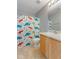 Well-lit bathroom with a single sink vanity and a fun, colorful dinosaur themed shower curtain at 800 Gondola Run, Greenfield, IN 46140