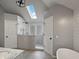 Modern bathroom featuring a glass shower, skylight, and neutral tile at 1242 Bitterwood Ct, Columbus, IN 47201
