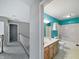 Bright bathroom featuring a double sink vanity, tub and shower combination, and teal accent wall at 1242 Bitterwood Ct, Columbus, IN 47201