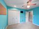 Bedroom featuring blue walls, carpeted floor, ceiling fan, closet, and a mounted television at 1242 Bitterwood Ct, Columbus, IN 47201