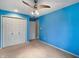 Bedroom featuring blue walls, carpeted floor, ceiling fan, and closet for ample storage at 1242 Bitterwood Ct, Columbus, IN 47201