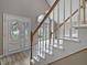 Bright entryway featuring an ornate front door, wood flooring, and a staircase with white and wood trim at 1242 Bitterwood Ct, Columbus, IN 47201