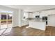 Modern kitchen with white cabinets, an island, stainless steel appliances, and sliding door access to the backyard at 67 Sterling Pl, New Whiteland, IN 46184