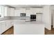 Bright kitchen with white cabinets, stainless steel appliances, quartz countertops, and a tile backsplash at 67 Sterling Pl, New Whiteland, IN 46184