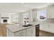 Open-concept kitchen showcasing a quartz island, white cabinets, and modern appliances flowing into the living space at 67 Sterling Pl, New Whiteland, IN 46184