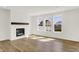 Sun-drenched living room featuring a fireplace, wood-look floors, and backyard views at 67 Sterling Pl, New Whiteland, IN 46184