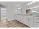 Bathroom featuring dual sinks, large vanity and view into bedroom at 10603 Banyan Wood Ct, Indianapolis, IN 46239