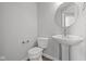 Elegant powder room with pedestal sink, modern fixtures and round mirror at 10603 Banyan Wood Ct, Indianapolis, IN 46239