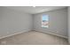 A spacious bedroom with carpet flooring, neutral walls, and a window offering outdoor views at 10603 Banyan Wood Ct, Indianapolis, IN 46239
