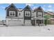 Gorgeous new construction home featuring a three car garage, dark trim, and an inviting front porch at 10603 Banyan Wood Ct, Indianapolis, IN 46239