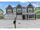 Beautiful new construction home featuring a three car garage, dark trim, and an inviting front porch at 10603 Banyan Wood Ct, Indianapolis, IN 46239