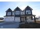 Two-story farmhouse-style home with a three-car garage and dark gray siding at 10603 Banyan Wood Ct, Indianapolis, IN 46239