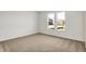 Empty bedroom features neutral walls, carpet, and a large window providing natural light at 68 Sterling Pl, New Whiteland, IN 46184