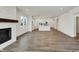 Bright open-concept living space with hardwood floors, modern fireplace, and open view to the kitchen at 68 Sterling Pl, New Whiteland, IN 46184