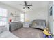 Bedroom featuring a gray crib, changing table, soft armchair, and ample natural light at 8908 Torrance Pl, Fishers, IN 46038