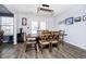 Well-lit dining room features modern chandelier, wood flooring, and easy access to the backyard through glass patio doors at 8908 Torrance Pl, Fishers, IN 46038