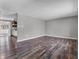 Open-concept living room with wood floors and neutral gray walls, open to the kitchen at 9829 Chambray Dr, Indianapolis, IN 46280