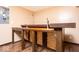 A basement bar with wood-look flooring, a wooden bar and walls painted in neutral colors at 13834 Keams Dr, Fishers, IN 46038