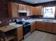 Bright kitchen with wood cabinets, stainless steel appliances, and a brick accent wall at 502 E 9Th St, Sheridan, IN 46069