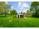 A well-maintained backyard features a detached garage, green grass, and an ornate wishing well at 56 Hadley Woodland St, Mooresville, IN 46158