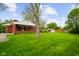 Large backyard with green lawn, shed, and the back of the brick house at 56 Hadley Woodland St, Mooresville, IN 46158