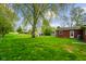Expansive backyard with a detached garage, well-kept lawn, and mature trees bordering the property at 56 Hadley Woodland St, Mooresville, IN 46158