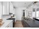 Contemporary kitchen featuring white cabinetry, a gray island with seating, and modern light fixtures at 17368 Pinellas Ave, Westfield, IN 46074
