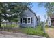 Charming blue house featuring a fenced yard, two windows, and mature trees at 2218 N Arsenal Ave, Indianapolis, IN 46218
