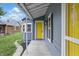 Charming front porch with gray siding and a bright yellow front door at 2218 N Arsenal Ave, Indianapolis, IN 46218