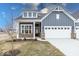 Charming blue two-story home featuring a brick foundation, white trim, and an attached two car garage at 3922 Holly Brook Dr, Westfield, IN 46062
