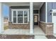 Welcoming covered entryway with brick accents and a modern black front door at 3922 Holly Brook Dr, Westfield, IN 46062
