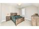 Charming bedroom with a rustic wooden bed frame and green blanket at 520 Bridgemont Ln, Carmel, IN 46032