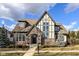 Charming two-story home features a combination of brick and stucco, with a steeply pitched roof and professionally landscaped yard at 520 Bridgemont Ln, Carmel, IN 46032