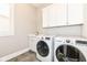 Bright laundry room with front-load washer and dryer and white cabinets at 520 Bridgemont Ln, Carmel, IN 46032