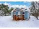 Charming blue house with wooden porch and steps, snowy yard at 7401 Mt Herman Ave, Indianapolis, IN 46231