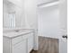 Well-lit bathroom featuring a quartz countertop vanity, modern mirror, and luxury vinyl plank flooring at 7840 Magnolia St, New Palestine, IN 46163