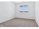 A bedroom with a window overlooking a snowy outdoor scene and neutral carpet flooring at 7840 Magnolia St, New Palestine, IN 46163