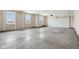 Unfinished garage with concrete floors, drywall, windows and an insulated garage door at 7840 Magnolia St, New Palestine, IN 46163