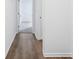 Hallway with wood-look floors connecting carpeted bedrooms, offering a transition between spaces at 7840 Magnolia St, New Palestine, IN 46163