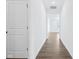 Hallway leading into a room with a window and light-colored luxury vinyl plank flooring at 7840 Magnolia St, New Palestine, IN 46163