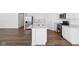 Kitchen boasts stainless appliances, island with sink, and white countertops at 7840 Magnolia St, New Palestine, IN 46163